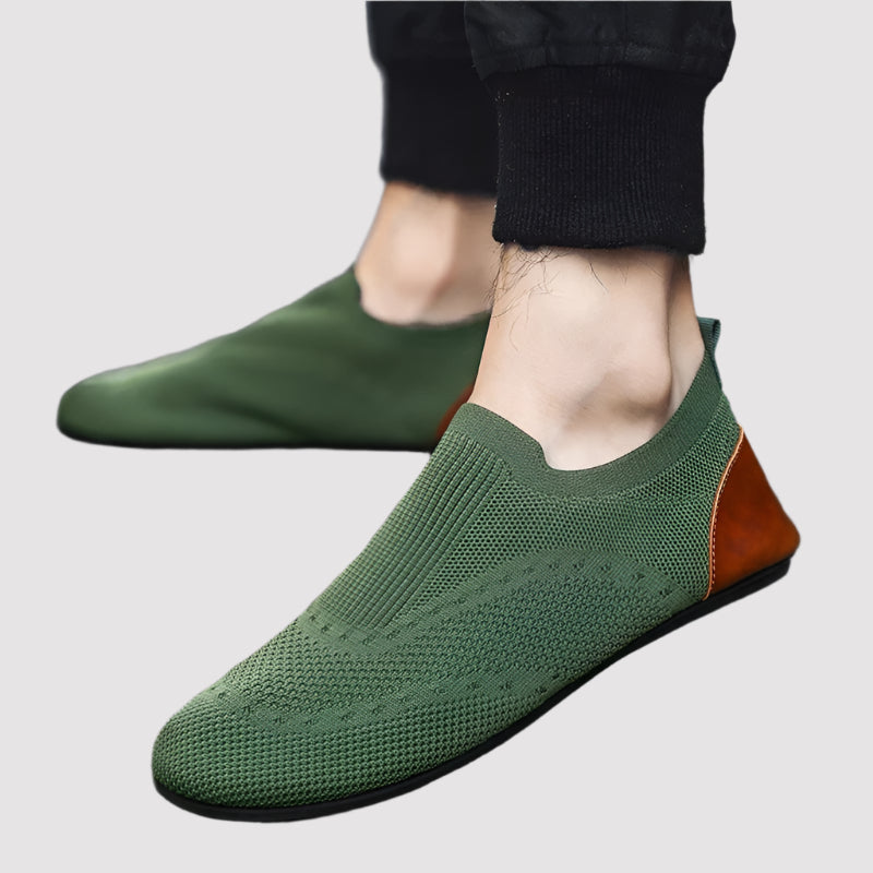 Green shoes with brown accents worn by a person on a gray pavement, featuring the RZL brand logo.